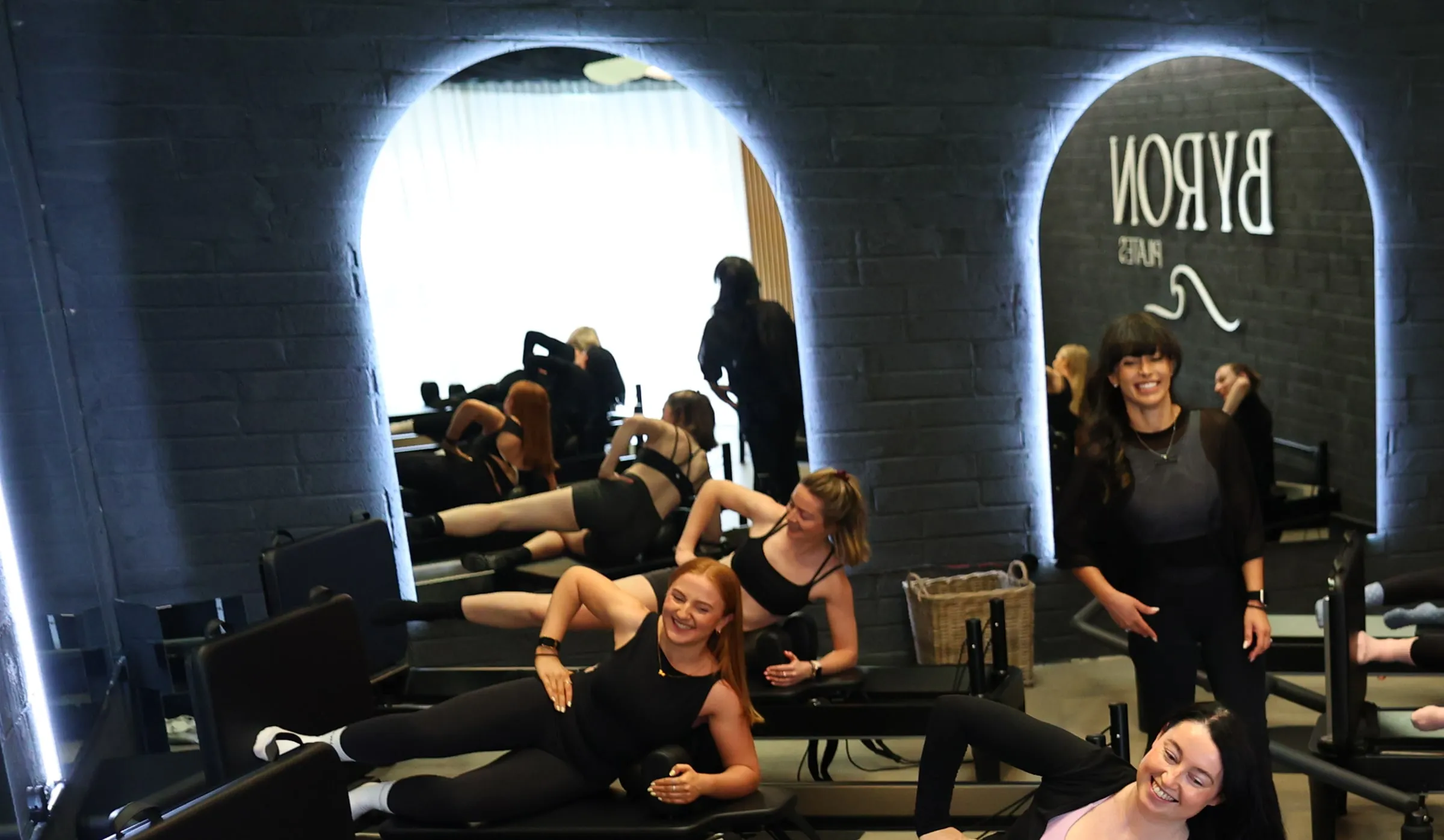 A full class on the reformers beneath the neon-lit arches